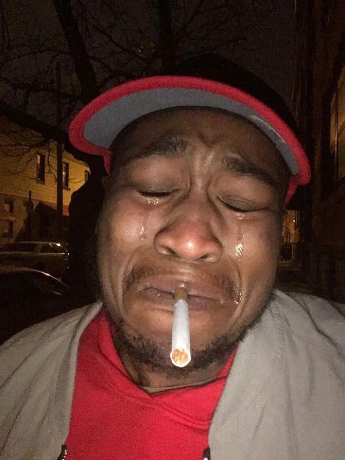 Hình ảnh người đàn ông da đen vừa hút thuốc vừa khóc