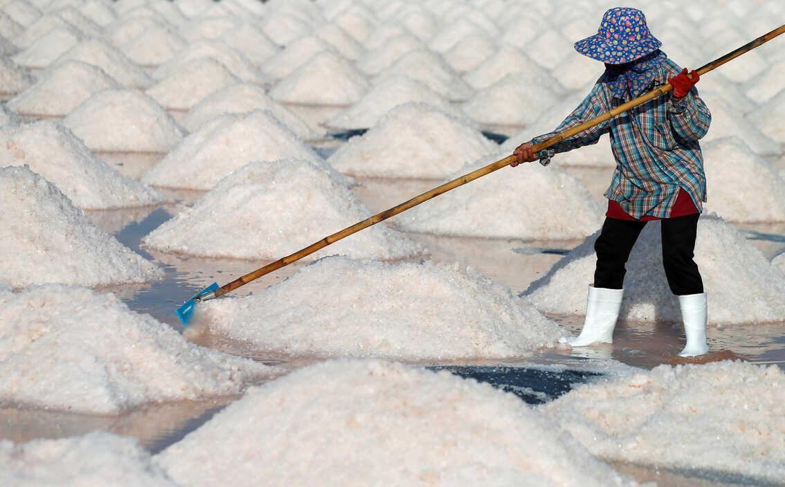 Hình ảnh người phụ nữ làm việc trên ruộng muối