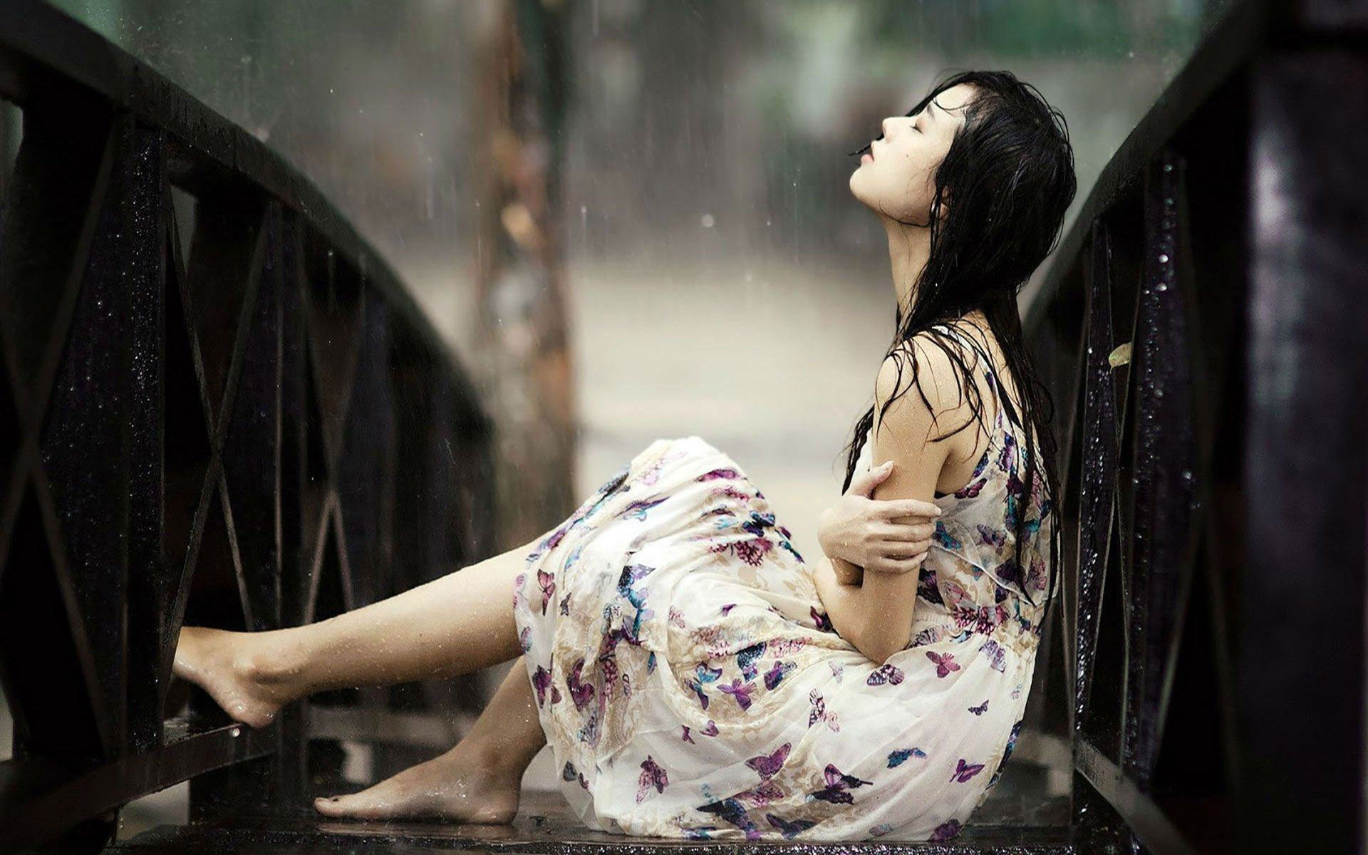 Cô gái ngồi trên cầu dưới mưa lạnh