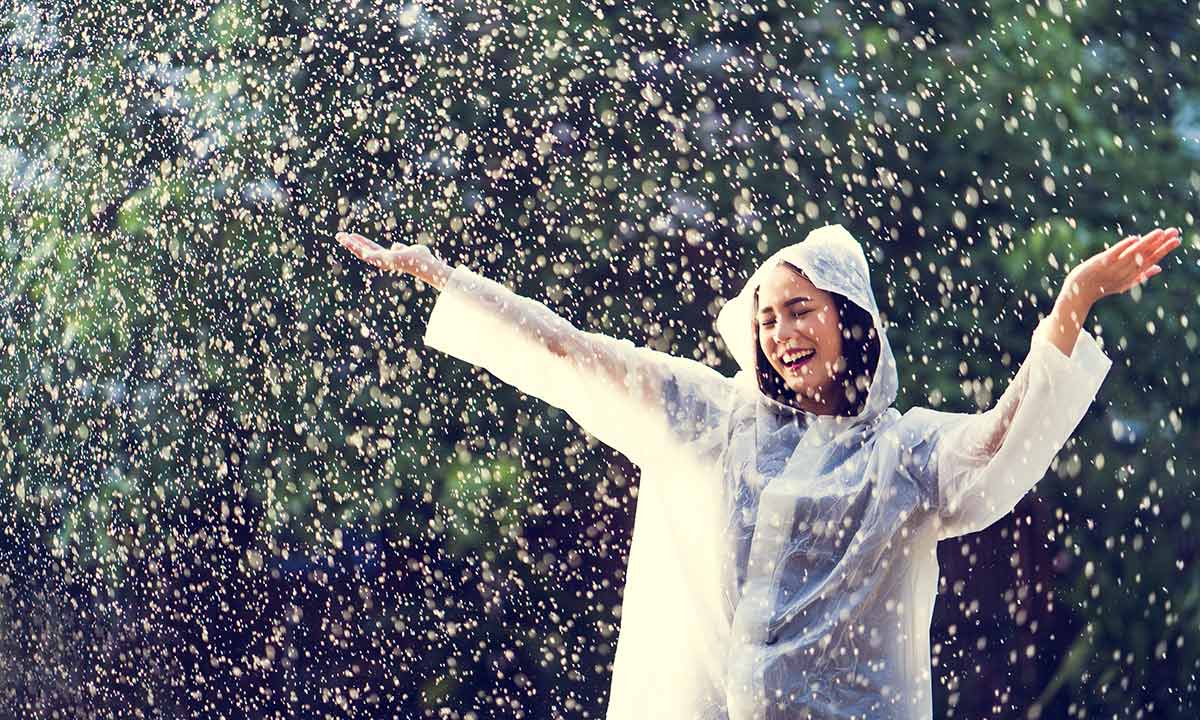 người phụ nữ vui vẻ dưới mưa
