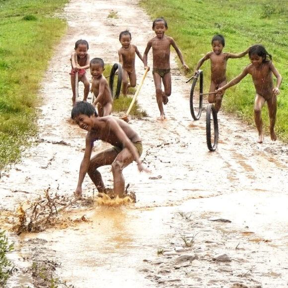 Hình ảnh trẻ em chơi trên cánh đồng dưới trời mưa