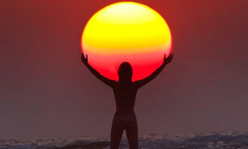 Hình ảnh một người dang rộng hai tay như ôm lấy mặt trời lặn