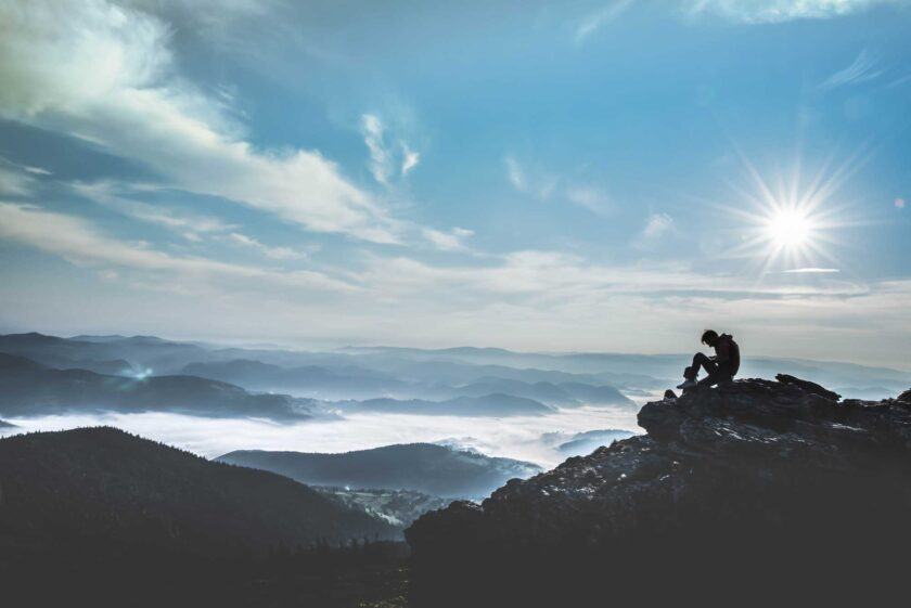 hình ảnh một người ngồi một mình trên đỉnh núi cô đơn