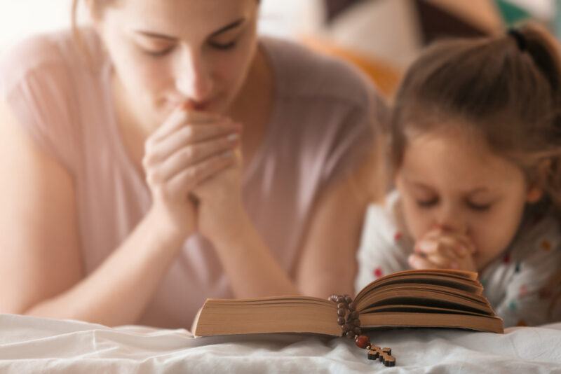 Cô gái theo đạo thiên chúa và mẹ cô ấy đang cầu nguyện cho indoo kinh thánh